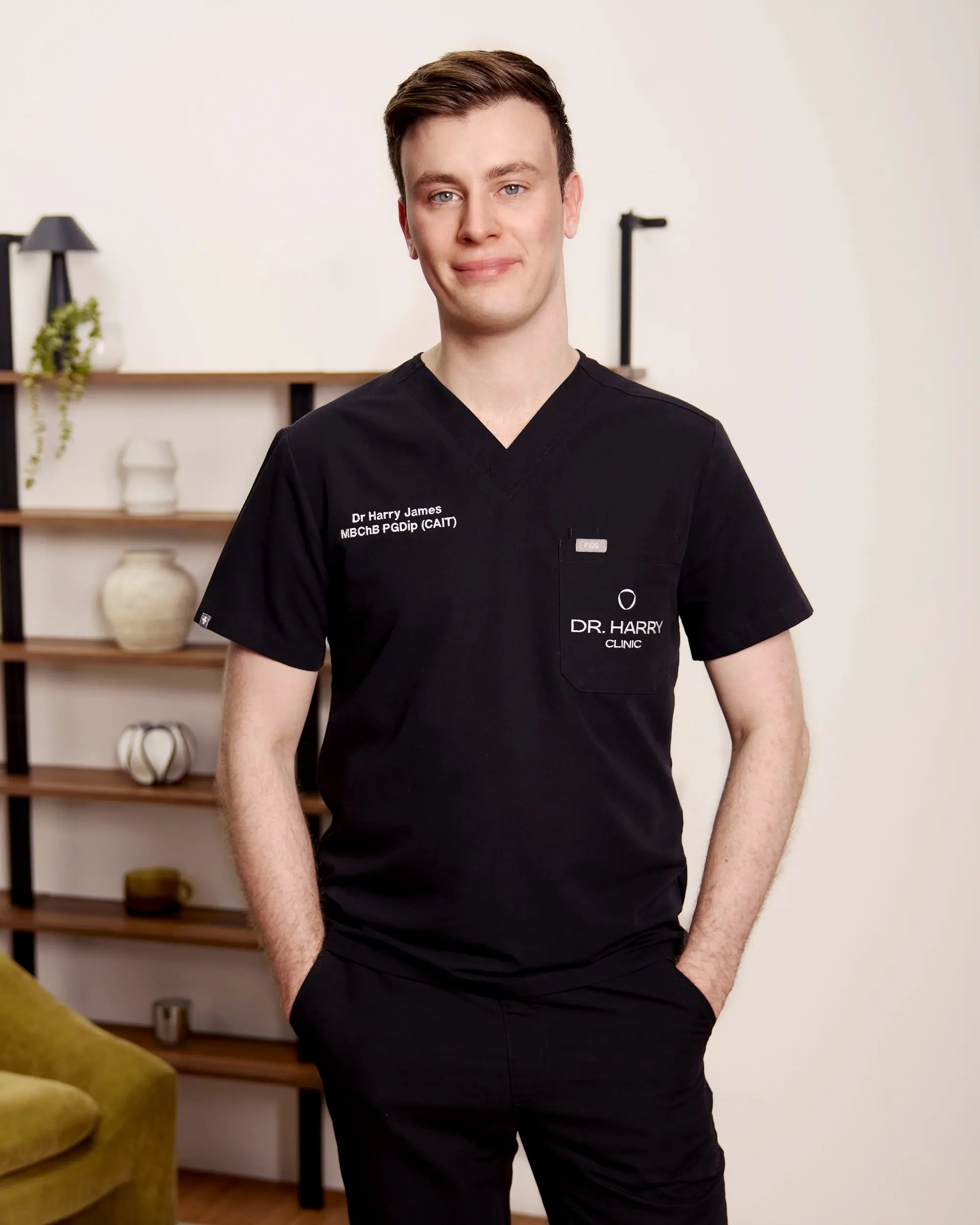 Dr Harry James standing beside the olive armchair in the consultation room